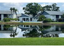 Scenic view of the community pool and clubhouse overlooking a tranquil pond, creating a relaxing atmosphere at 11201 122Nd Ave # 129, Largo, FL 33778