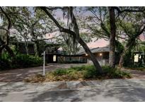 Charming exterior view of home featuring mature landscaping and a spacious driveway at 1296 Weybridge Ln, Dunedin, FL 34698