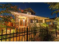 Charming home exterior featuring a well-lit porch, manicured landscaping, and an elegant wrought iron fence at 135 12Th Ne Ave, St Petersburg, FL 33701