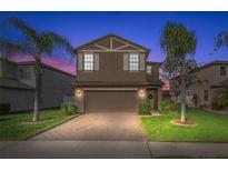 Charming two-story home featuring a paved driveway, two-car garage and manicured lawn at 1726 Hadden Hall Pl, Trinity, FL 34655