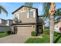 Charming two-story home features a well-manicured lawn, brick driveway, and attached two-car garage at 1726 Hadden Hall Pl, Trinity, FL 34655