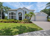 Beautiful two-story home boasts manicured lawn, lush landscaping and a large front yard at 18107 Sugar Brooke Dr, Tampa, FL 33647