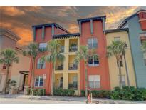 Colorful multi-story condo building with palm trees and private balconies on a sunny day at 2402 Azeele W St # 412, Tampa, FL 33609