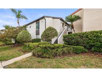 Charming condo exterior with manicured landscaping, mature palms, and a private entrance at 2597 Countryside Blvd # 206, Clearwater, FL 33761