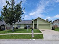 Charming single-story home featuring lush lawn, mature trees and a attached two-car garage at 2816 Manor Hill Dr, Brandon, FL 33511