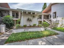 Well-maintained condo complex exterior with manicured landscaping and inviting walkways at 300 S Florida Ave # 200J, Tarpon Springs, FL 34689