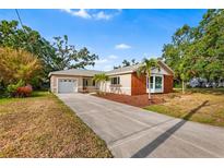 Charming single-story home with a well-manicured lawn and a long driveway to an attached garage at 3417 1St W Ave, Bradenton, FL 34205