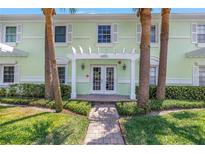 Inviting building entrance with palm trees, a white pergola, and brick walkway at 5037 Starfish Se Dr # A, St Petersburg, FL 33705