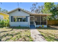 Charming home with a screened-in front porch, landscaped yard, and classic architectural details at 5806 N 9Th St, Tampa, FL 33604