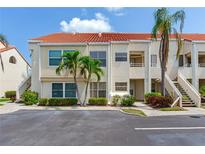 Inviting two-story condo featuring a red tile roof, lush landscaping, and convenient parking at 6171 Bahia Del Mar Blvd # 216, St Petersburg, FL 33715