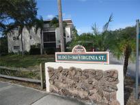 Patrician Oaks condo building sign surrounded by lush landscaping and tropical palm trees at 860 Virginia St # 308, Dunedin, FL 34698