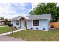 Charming single-story home with blue stucco exterior, decorative wooden accents, and well-manicured lawn at 1114 Michigan N Dr, Dunedin, FL 34698