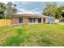 Charming brick home featuring a well-manicured front yard and a freshly painted driveway and garage door at 15307 Stonecreek Ln, Tampa, FL 33613