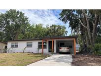 Charming single-story home featuring a carport, freshly painted exterior, and well-manicured lawn at 2312 W Kenmore Ave, Tampa, FL 33604