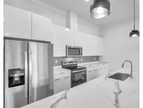 Modern kitchen with stainless steel appliances, white cabinets and a beautiful waterfall island at 2608 W Columbus Dr # 3, Tampa, FL 33607