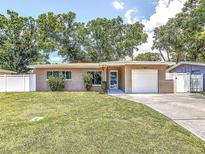 Charming single-story home featuring a well-manicured lawn, attached garage, and inviting curb appeal at 2933 Stratford Dr, Largo, FL 33771