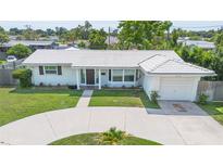 Charming single-story home featuring a well-manicured lawn and a circular driveway leading to an attached garage at 3300 58Th N St, St Petersburg, FL 33710