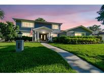 Beautiful two-story home with manicured lawn, lovely landscaping, and a charming walkway leading to the front door at 3304 Latania Dr, Tampa, FL 33618