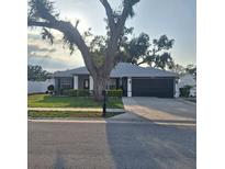 Charming one-story home with a well-maintained lawn, mature trees and a two car garage at 37535 Laurel Hammock Dr, Zephyrhills, FL 33541