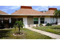 Charming single-story condo featuring a well-maintained lawn and covered front porch at 4345 Tahitian Gardens Cir # C, Holiday, FL 34691