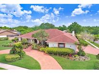 Beautiful one-story home with manicured lawn, red brick driveway, and lush landscaping at 5112 Lanai Way, Tampa, FL 33624