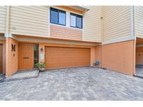 A home exterior with a brick driveway, door on the left, and a two-car garage at 531 Sandy Hook Rd, Treasure Island, FL 33706