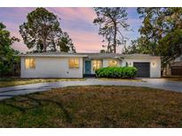 Charming single-story home featuring a gray driveway, minimalist landscaping and stylish blue door at 6120 5Th N Ave, St Petersburg, FL 33710