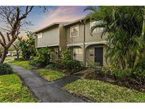 Inviting townhouse featuring lush landscaping and a charming covered entryway at 7606 Woodbridge Blvd, Tampa, FL 33615