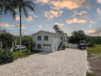 Beautiful exterior of a two-story home with a brick driveway and lush tropical landscaping at 8117 Bay Dr, Tampa, FL 33635
