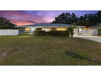 Charming single-story home featuring a well-manicured lawn and a neatly landscaped front yard at 895 Joan St, Dunedin, FL 34698