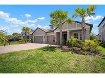 Beautiful single-Gathering home with a two-car garage, lush lawn, and lovely landscaping including palm trees at 923 Whimbrel Run, Bradenton, FL 34212