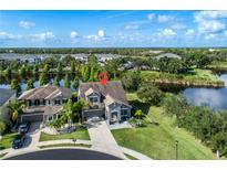 Stunning aerial view of a home with lush landscaping and a private lake in a desirable community at 11320 Lazy Hickory Ln, Tampa, FL 33635
