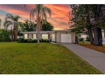 Charming single-story home with a well-manicured lawn, palm trees, and a one-car garage at 119 N Hillcrest Ave, Clearwater, FL 33755