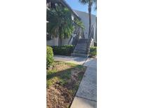 Exterior view of the building with stairs and lush landscaping at 2017 Skimmer W Ct # 413, Clearwater, FL 33762