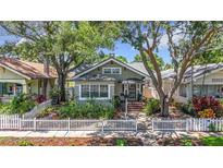 Charming home featuring mature trees, white picket fence, and a welcoming landscaped front yard at 231 15Th Ne Ave, St Petersburg, FL 33704