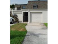 Townhouse exterior featuring garage, front door, and well-maintained landscaping at 2980 Haines Bayshore Rd # 124, Clearwater, FL 33760