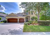 Charming two-story home featuring a three-car garage, manicured lawn, and mature landscaping at 3323 Anna George Dr, Valrico, FL 33596