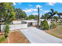 Charming single-story home with a carport, well-maintained lawn, and a white fence offering curb appeal at 3501 63Rd N St, St Petersburg, FL 33710