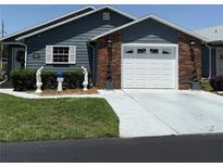 Charming single-story home with brick accents, a well-maintained lawn, and a two-car garage at 37401 Teaberry Loop, Zephyrhills, FL 33542