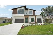 Stunning modern home with a sleek design, well-manicured lawn, and a spacious three-car garage at 3817 W San Nicholas St, Tampa, FL 33629