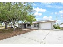 Charming single-story home featuring a well-manicured lawn, a driveway, and an attached garage at 4558 23Rd N Ave, St Petersburg, FL 33713