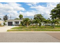 Charming single-story home with a well-manicured lawn and lush palm trees enhancing its curb appeal at 4601 83Rd N Ave, Pinellas Park, FL 33781
