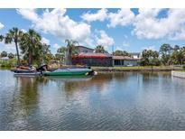 Waterfront property featuring boat and jet ski, with canal access and lush tropical landscaping at 5144 Cedarbrook Ln, Hernando Beach, FL 34607