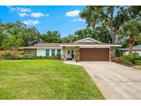 Charming single-story home featuring a manicured lawn, stone accents, and a two-car garage at 535 Sandy Hook, Palm Harbor, FL 34683