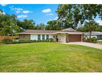 Lovely one-story home with lush green lawn, stone facade, and an attached garage at 535 Sandy Hook, Palm Harbor, FL 34683