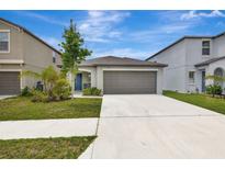 Charming single-Gathering home with a well-maintained lawn and a two-car garage on a sunny day at 7225 Ronnie Gardens Ct, Tampa, FL 33619