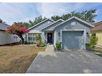 Charming single-story home featuring a beautiful flower tree, attached garage, and a welcoming front door with a wreath at 759 Cape Cod Cir, Valrico, FL 33594