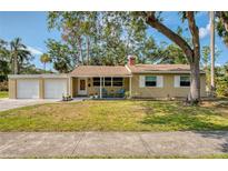 Inviting one-story home featuring a cozy front porch with seating and a lush green lawn at 770 27Th S Ave, St Petersburg, FL 33705
