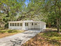 Charming single-story home featuring a convenient carport and freshly painted exterior at 7813 Cadillac Ave, Hudson, FL 34667