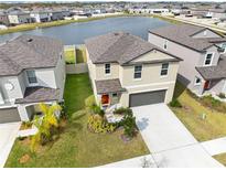 Beautiful two-story home with a well-manicured lawn, two-car garage, and peaceful water view at 9313 Lemon Drop Loop, Sun City Center, FL 33573